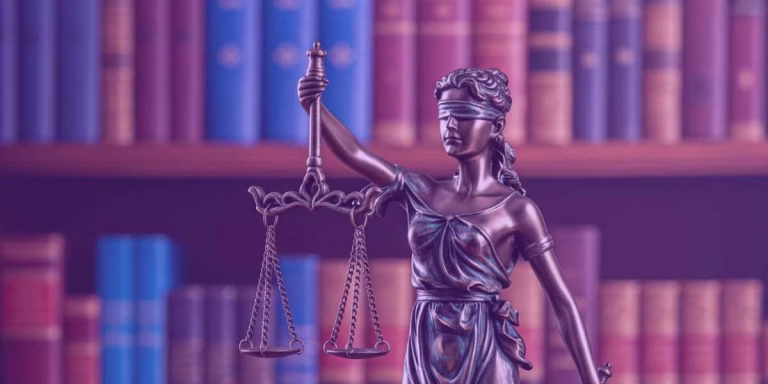 A imagem apresenta a estátua de uma figura simbólica da justiça, frequentemente associada à deusa