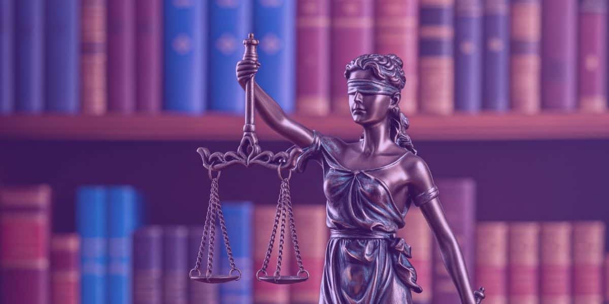A imagem apresenta a estátua de uma figura simbólica da justiça, frequentemente associada à deusa
