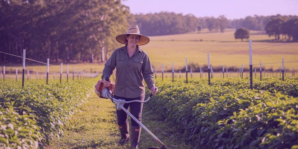 Uma mulher cuidando de seu terreno que adquiriu por posse em usucapião rural.