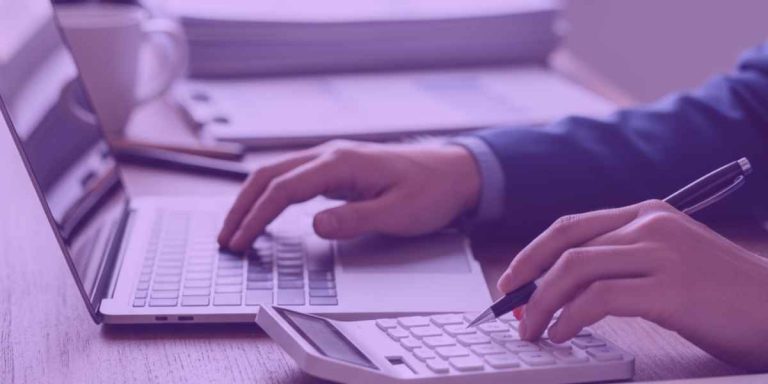 Advogado analisando dados financeiros em um notebook e calculadora, simbolizando estratégias de Recuperação de Crédito para Empresas.