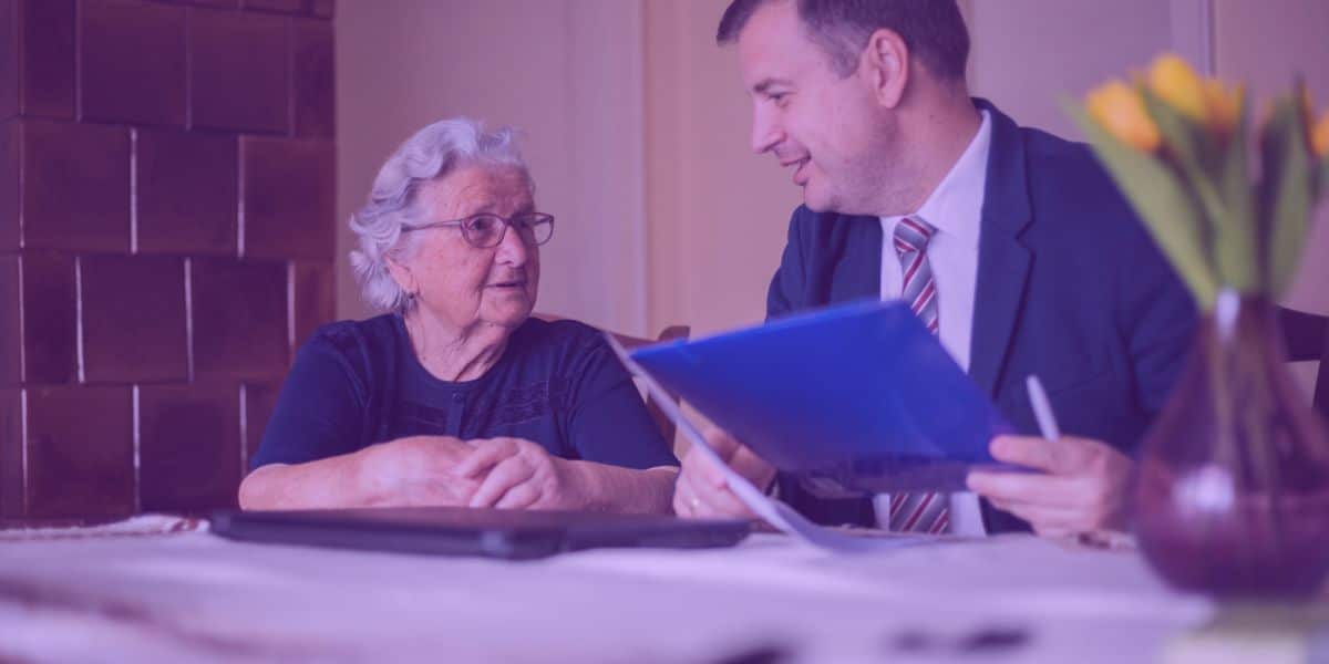 Uma senhora idosa conversando com seu advogado sobre planejamento sucessório.