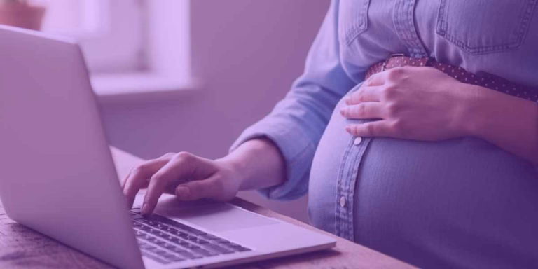 Mulher grávida pesquisando sobre o salário-maternidade
